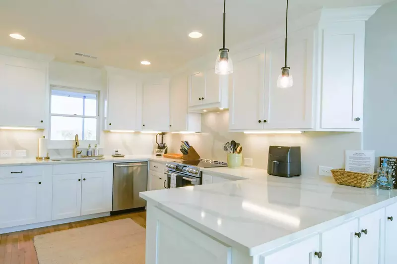 Opal House features a newly renovated kitchen with white cabinets, quartz counters and stainless steel appliances.