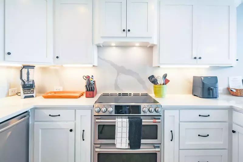 The kitchen has stainless steel appliances, including a GE induction double oven and cooktop range.
