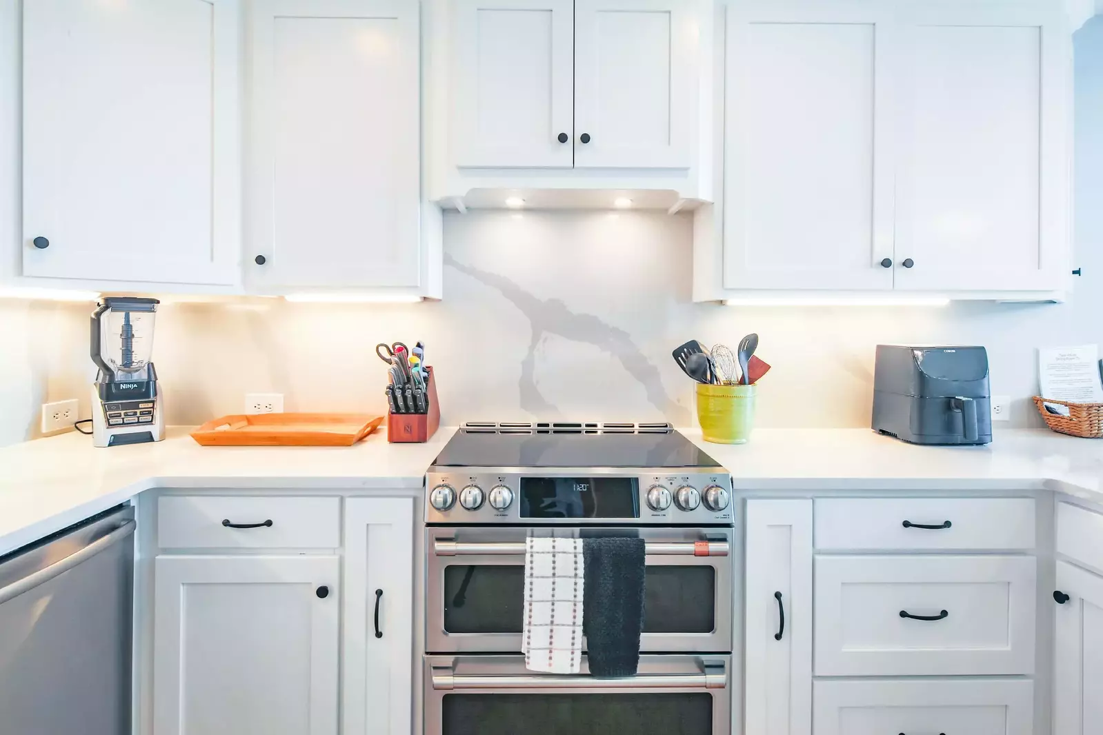 The kitchen has stainless steel appliances, including a GE induction double oven and cooktop range.