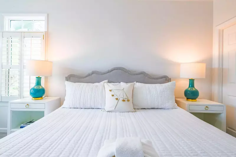 The king bed in the master suite is flanked by two nightstands with reading lamps.