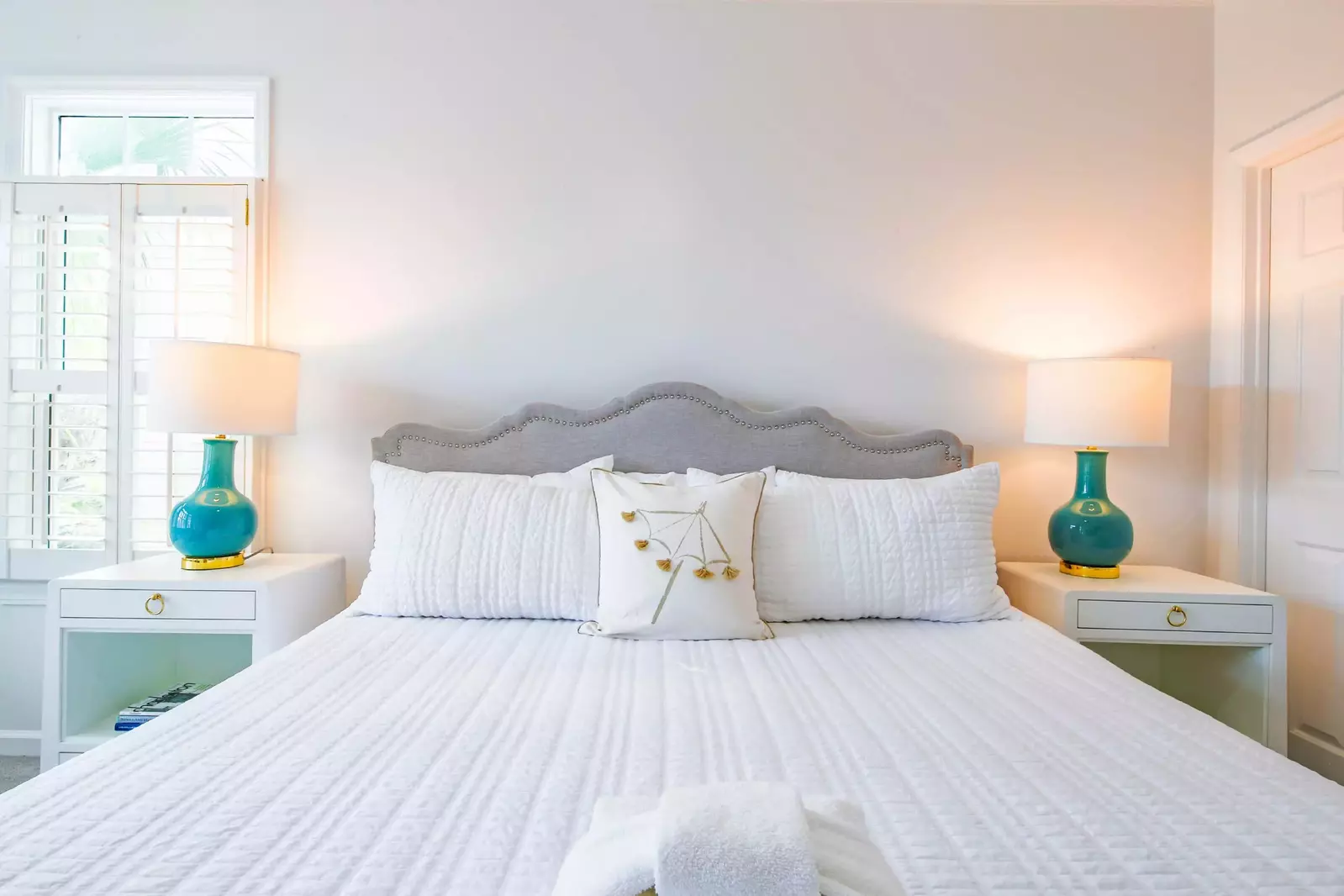 The king bed in the master suite is flanked by two nightstands with reading lamps.