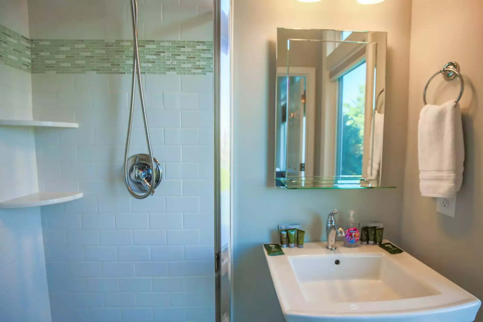 This en suite bathroom features a tiled walk-in shower and a pedestal sink.