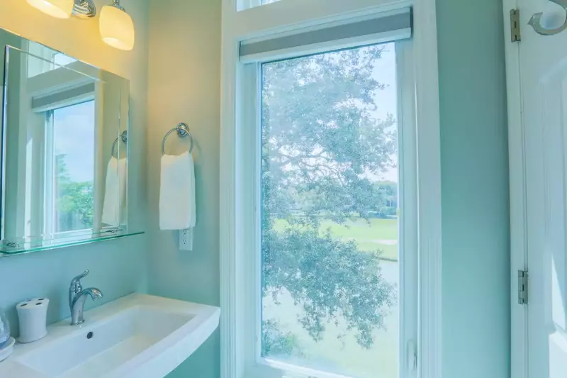The live oak tree outside the back of the home shapes the views from this bathroom window.