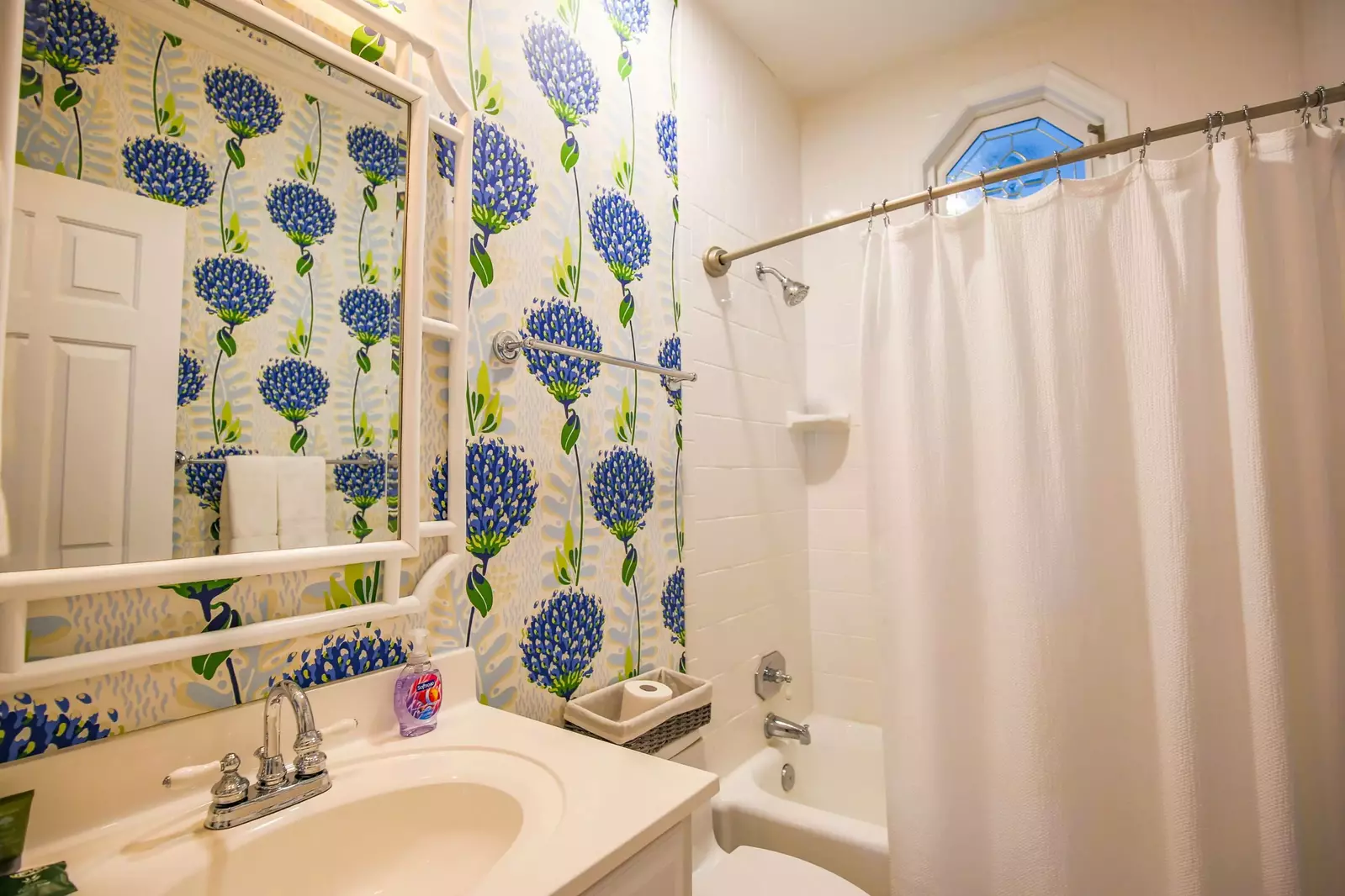 This bathroom, which is located off the 2nd floor hallway, has a tiled shower/tub combo.