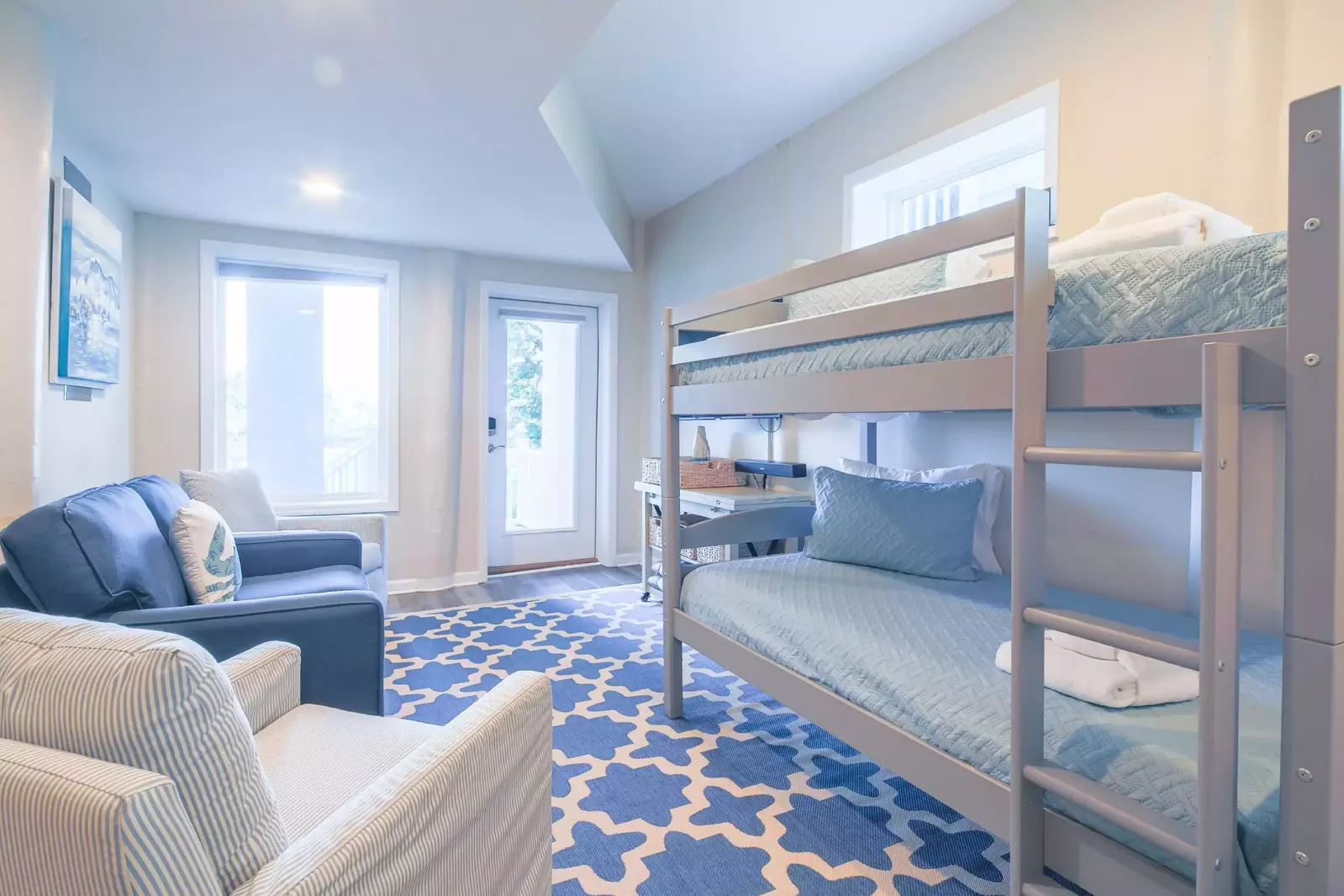 The ground floor is perfect for kids with this seating area, bunk beds and exterior access to the deck & backyard.