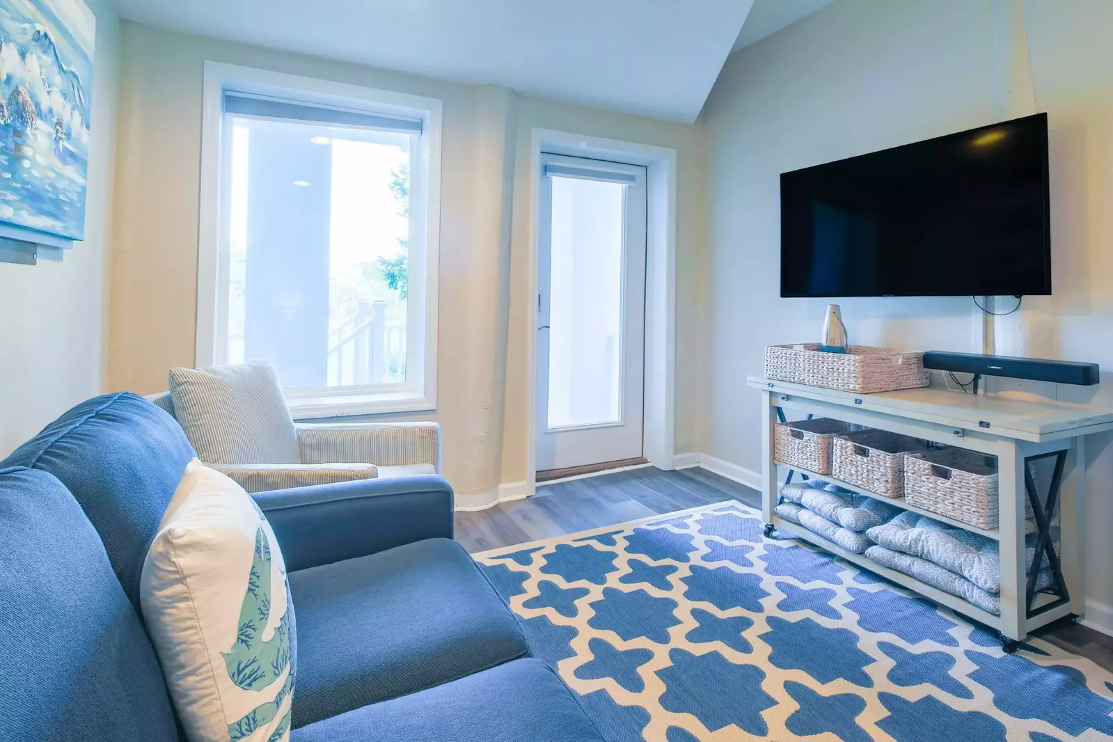 There is a large seating area, a wall-mounted smart TV and exterior access to the deck & backyard.