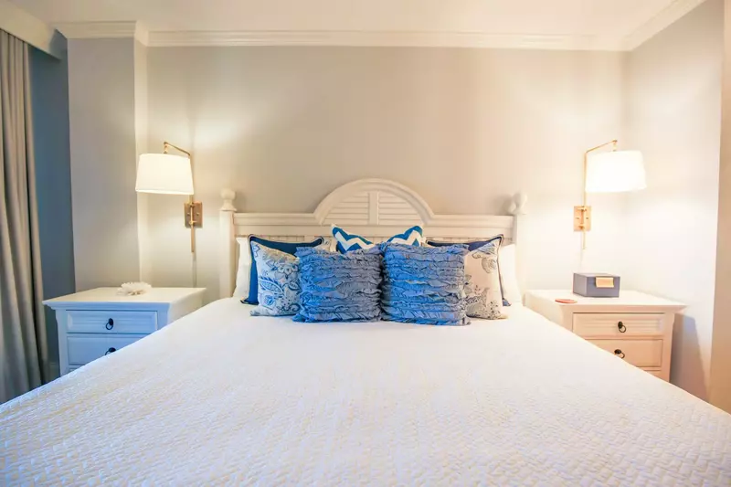 The master bedroom has a king bed, built-in reading lamps and two night stands.