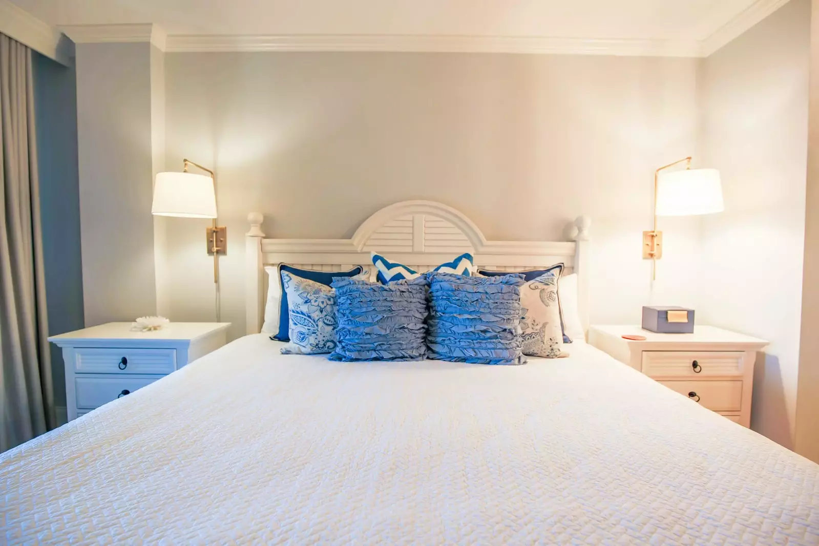 The master bedroom has a king bed, built-in reading lamps and two night stands.