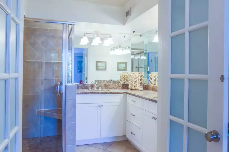 The en suite master bathroom features tiled floors, his & her sinks and a spacious vanity.