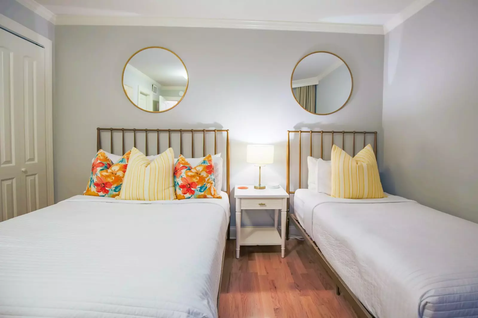 The guest bedroom also features wood floors and a night stand with reading lamp.