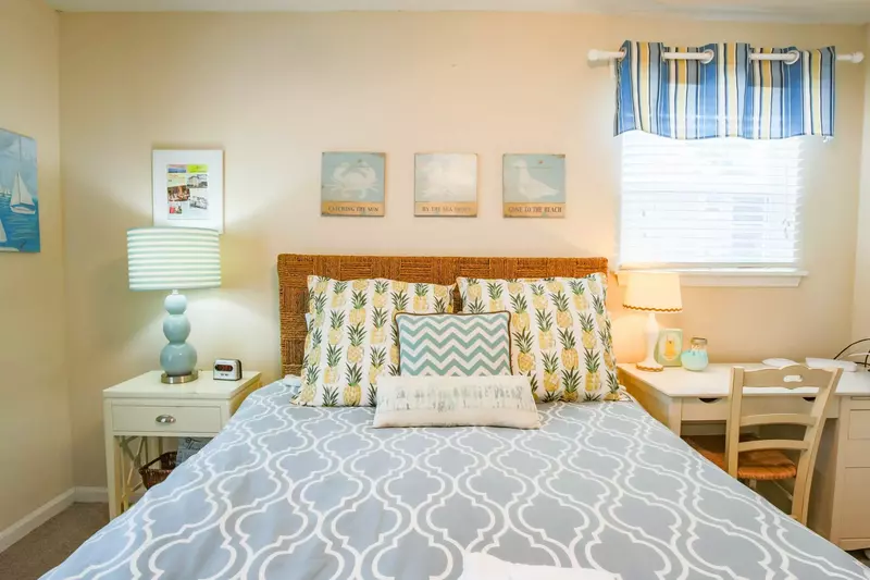 This ground floor bedroom features a queen bed, desk, nightstand and two reading lamps.