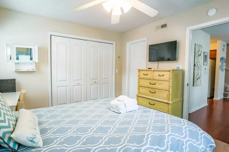 This guest bedroom has a mounted streaming TV, a dresser and shared access to the first floor bathroom.