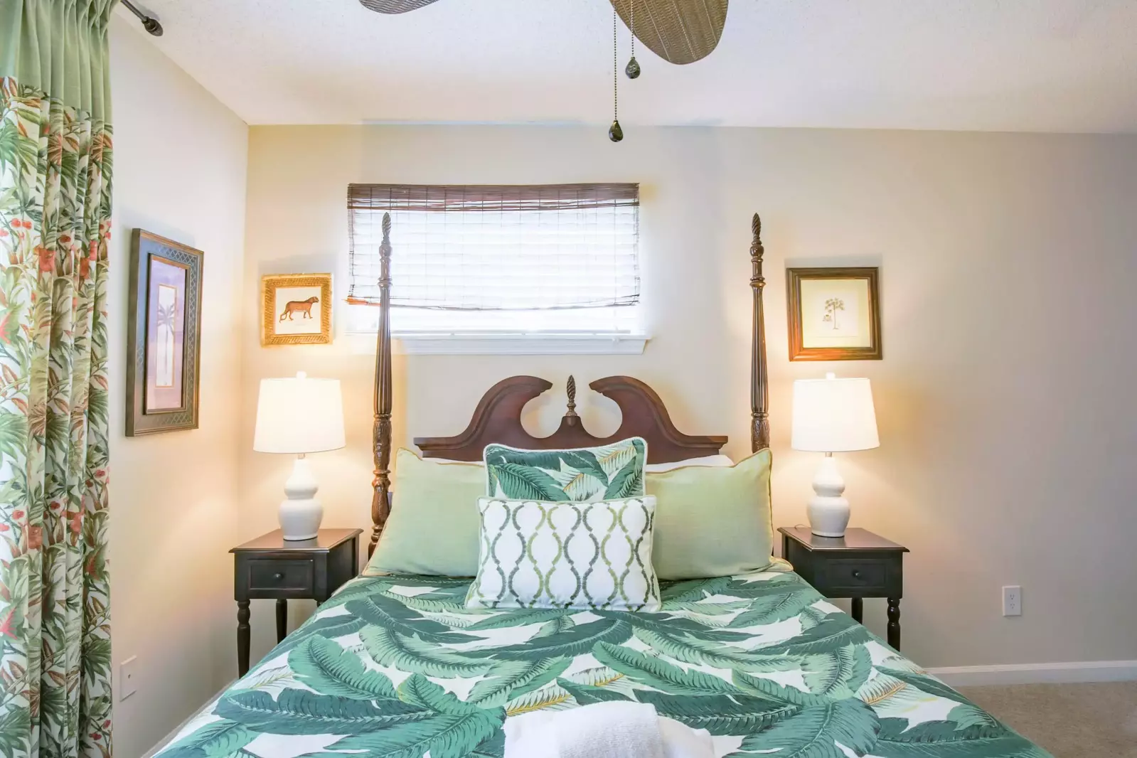 The home's master suite features a queen bed, nightstands with reading lamps and a ceiling fan.