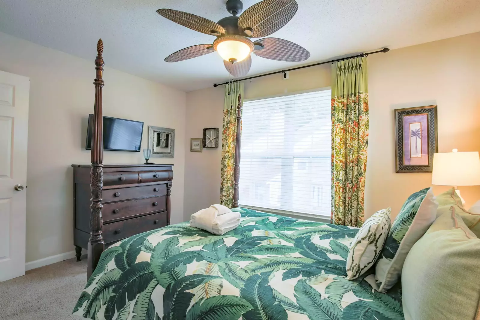 The master suite also has a dresser, mounted smart TV and an en suite bathroom.