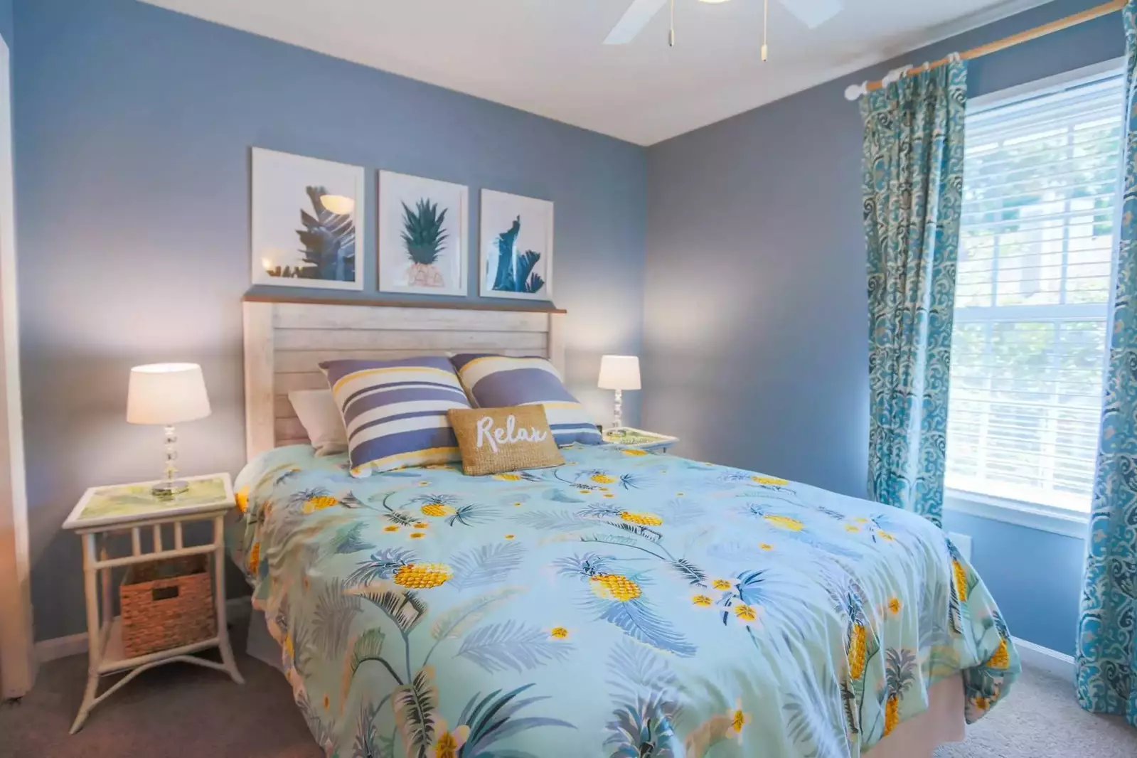 This guest suite on the second floor has a queen bed, nightstands with reading lamps and a ceiling fan.