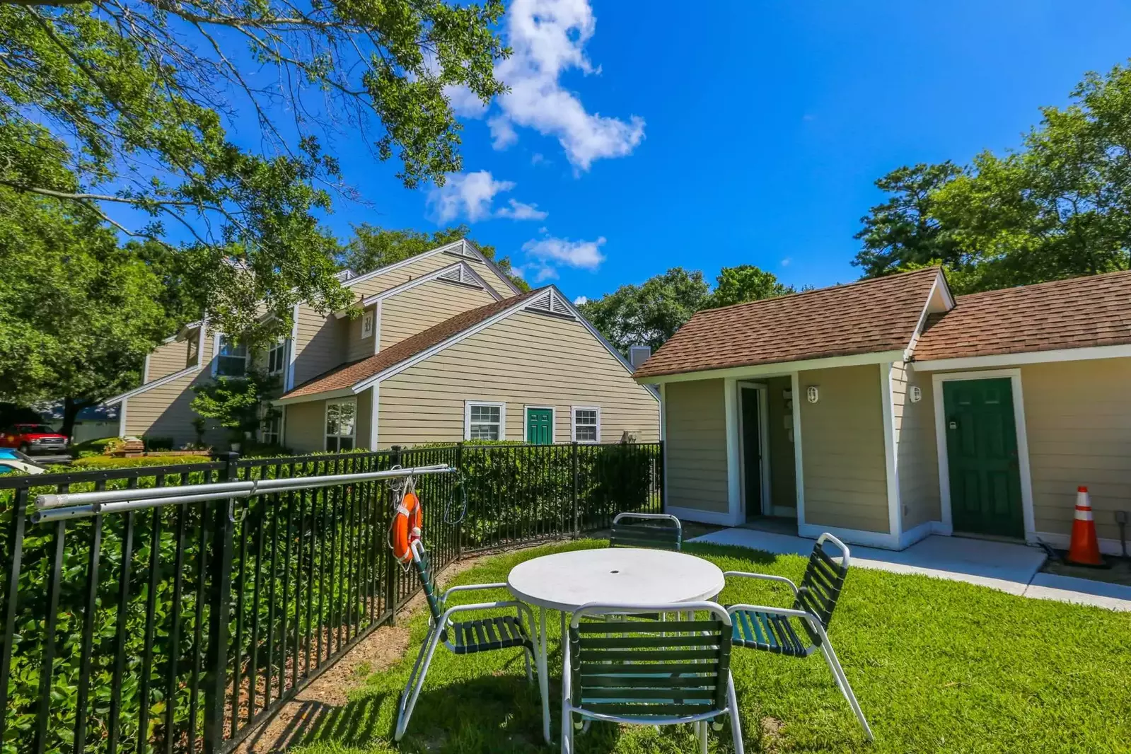 The community pool bathrooms are located just inside the small building near the outdoor dining table.