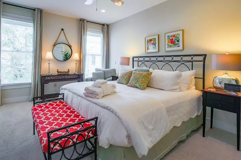 The ground floor master suite has a king bed, nightstands with reading lamps and ceiling fan.