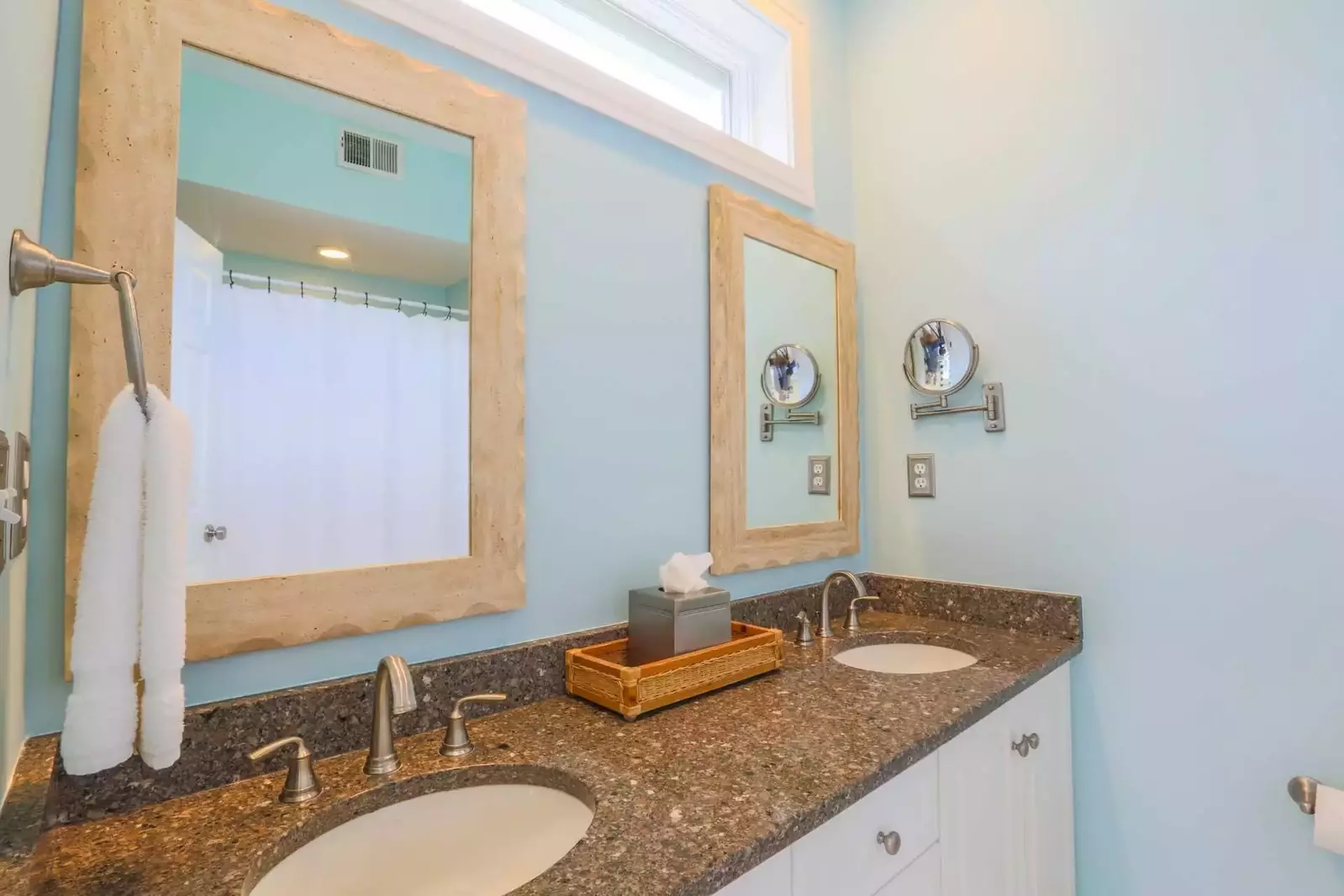 This en suite bathroom features a double sink vanity with granite countertops and a shower/tub combo.