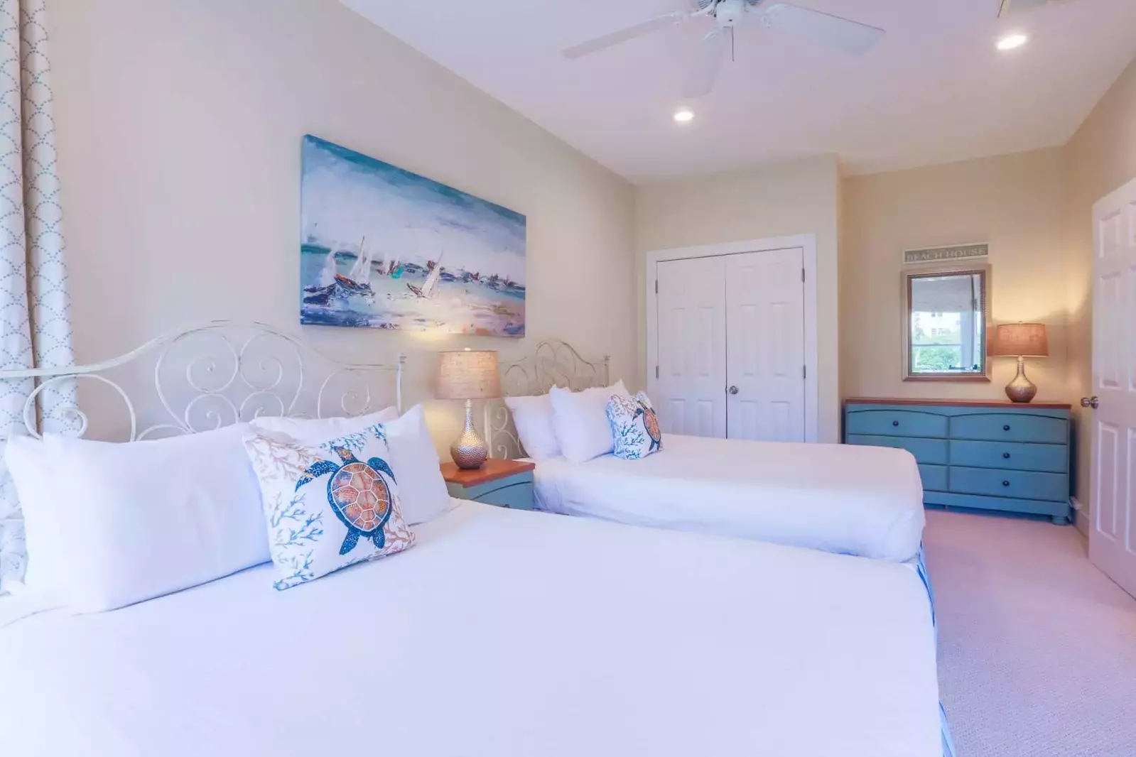 This queen suite has a dresser, ceiling fan and nightstand with a reading lamp.