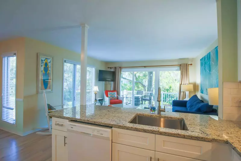 The newly renovated kitchen features new white cabinets, a tiled backsplash and granite counters.