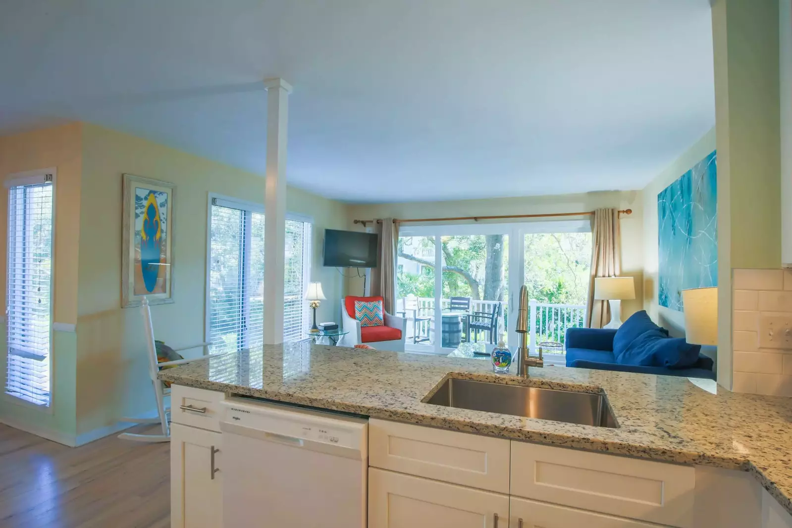 The newly renovated kitchen features new white cabinets, a tiled backsplash and granite counters.