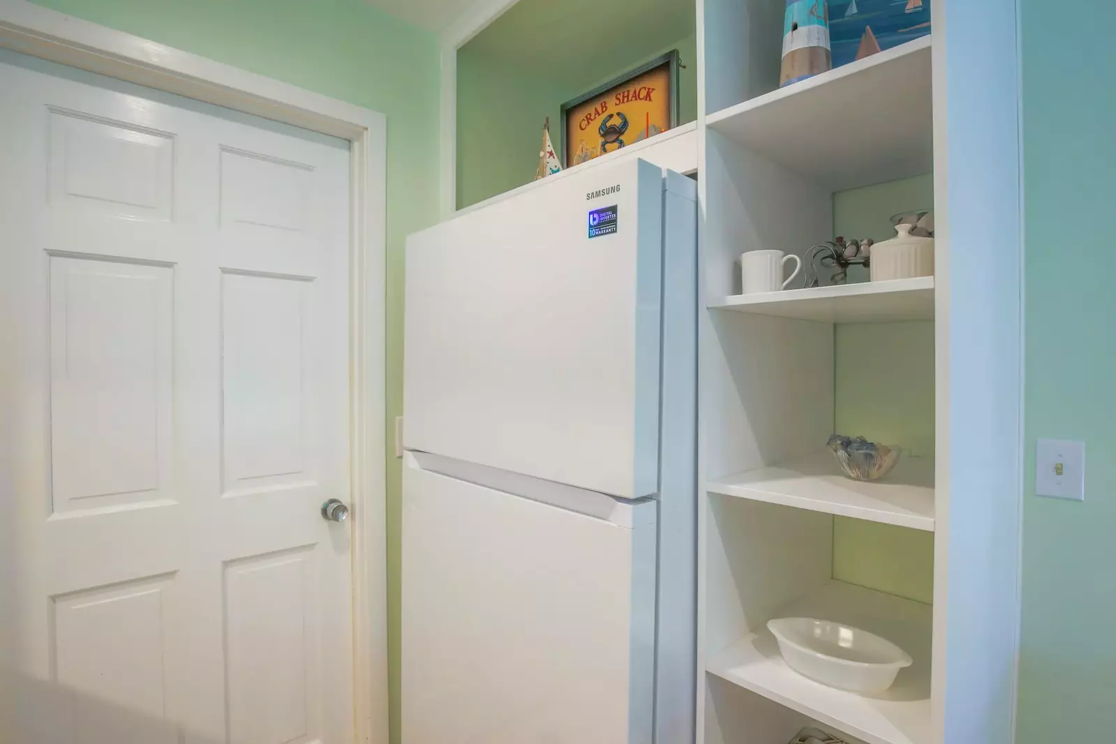 This door near the refrigerator in the kitchen leads to the home's laundry room.
