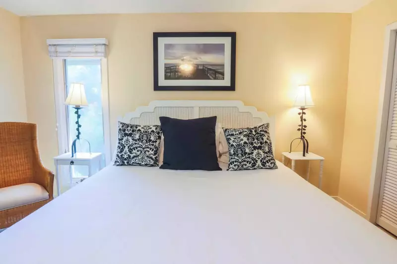 The master bedroom features a king bed, chair and nightstands with reading lamps.