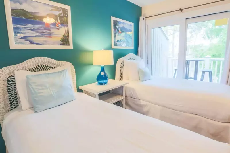 The guest bedroom has two twin beds and sliding door access to a private balcony.