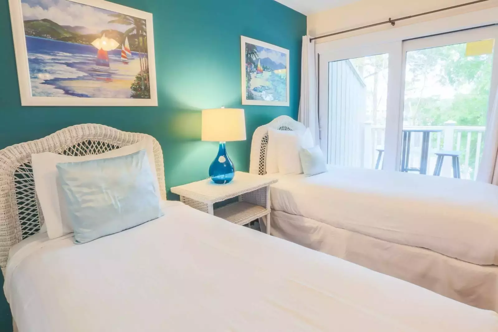 The guest bedroom has two twin beds and sliding door access to a private balcony.