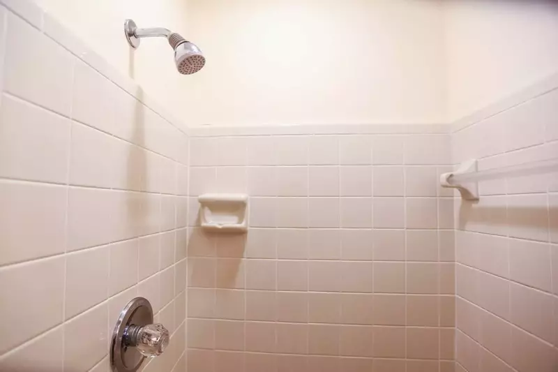The bathroom has a tiled shower.
