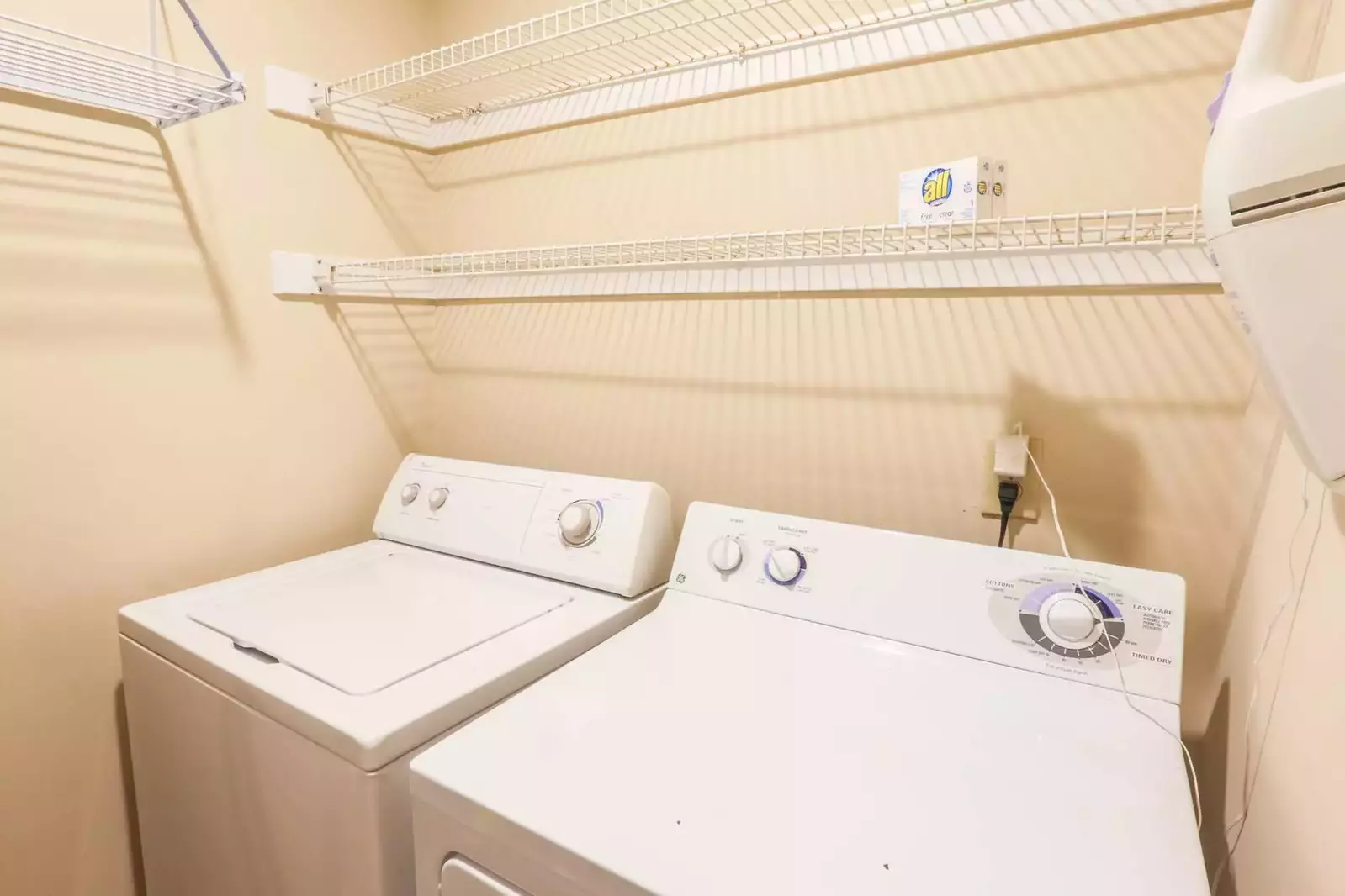 This full-sized washing machine and dryer are tucked away behind the kitchen.