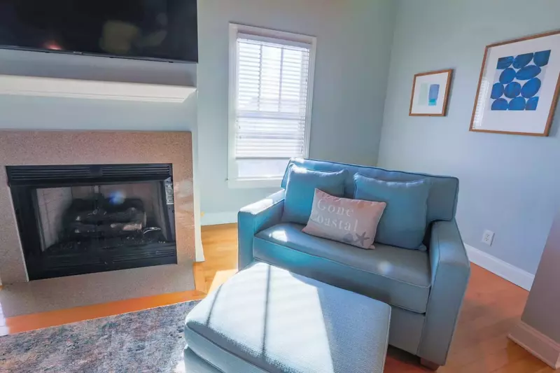 The living room is centered around the gas fireplace and mounted, large screen cable TV.