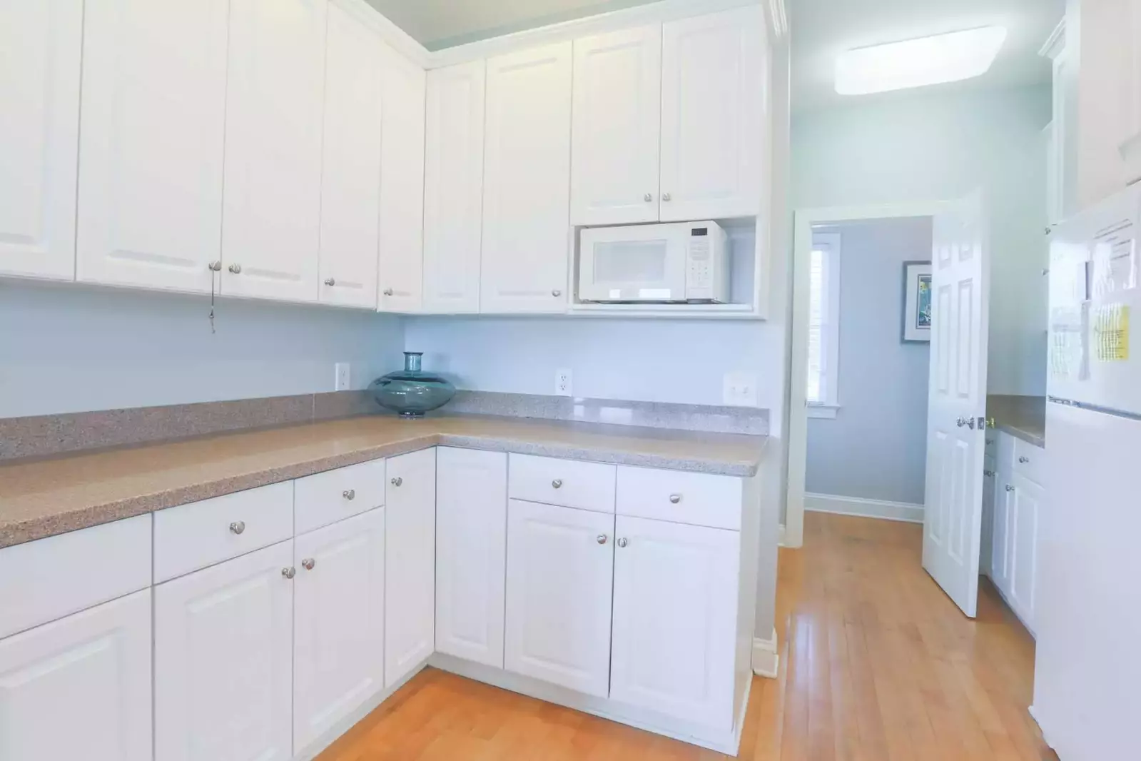 There is a pantry area and half bathroom tucked away behind the kitchen.