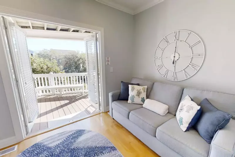 This den, which has a queen size sleeper sofa, accesses the covered deck on the first level of the home.