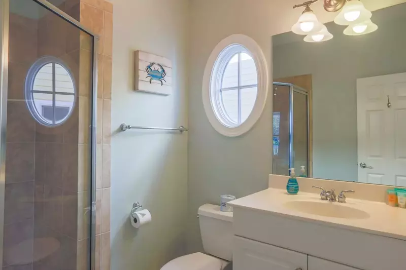 This en suite bathroom for the queen bedroom has a tiled, walk-in shower and vanity.