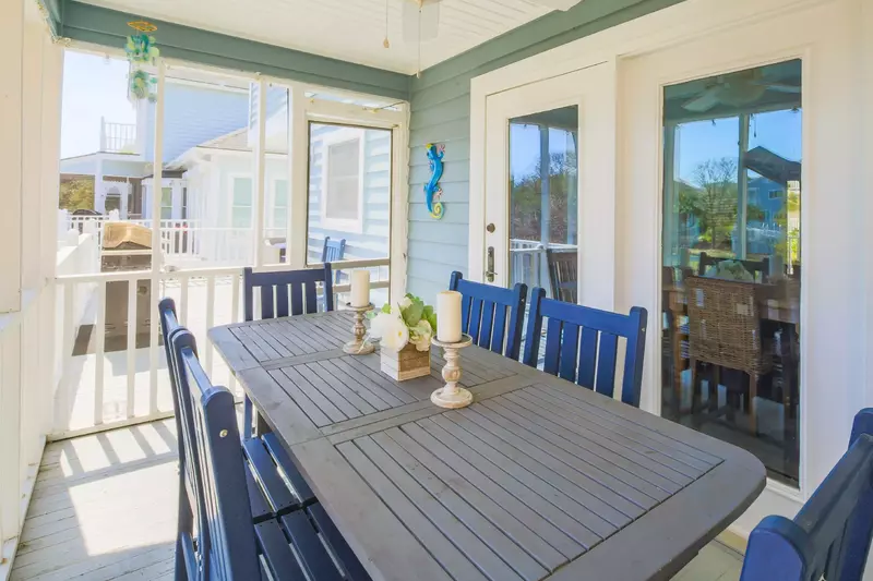 Step out of the back door onto the screened porch with an outdoor dining table.
