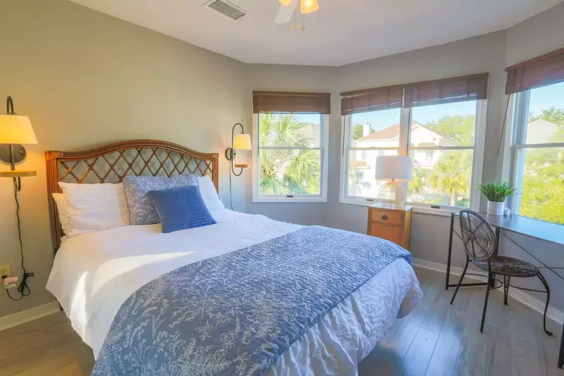 Upstairs you will find this guest bedroom suite with a queen bed, small desk and wall sconces.