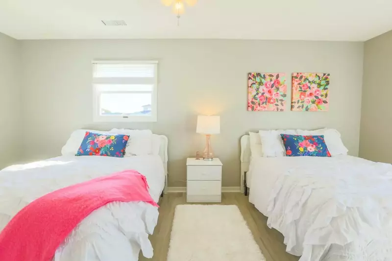 This guest bedroom suite features two queen beds and a night stand with reading lamp.