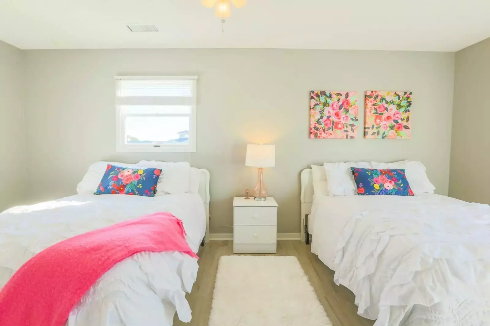 This guest bedroom suite features two queen beds and a night stand with reading lamp.
