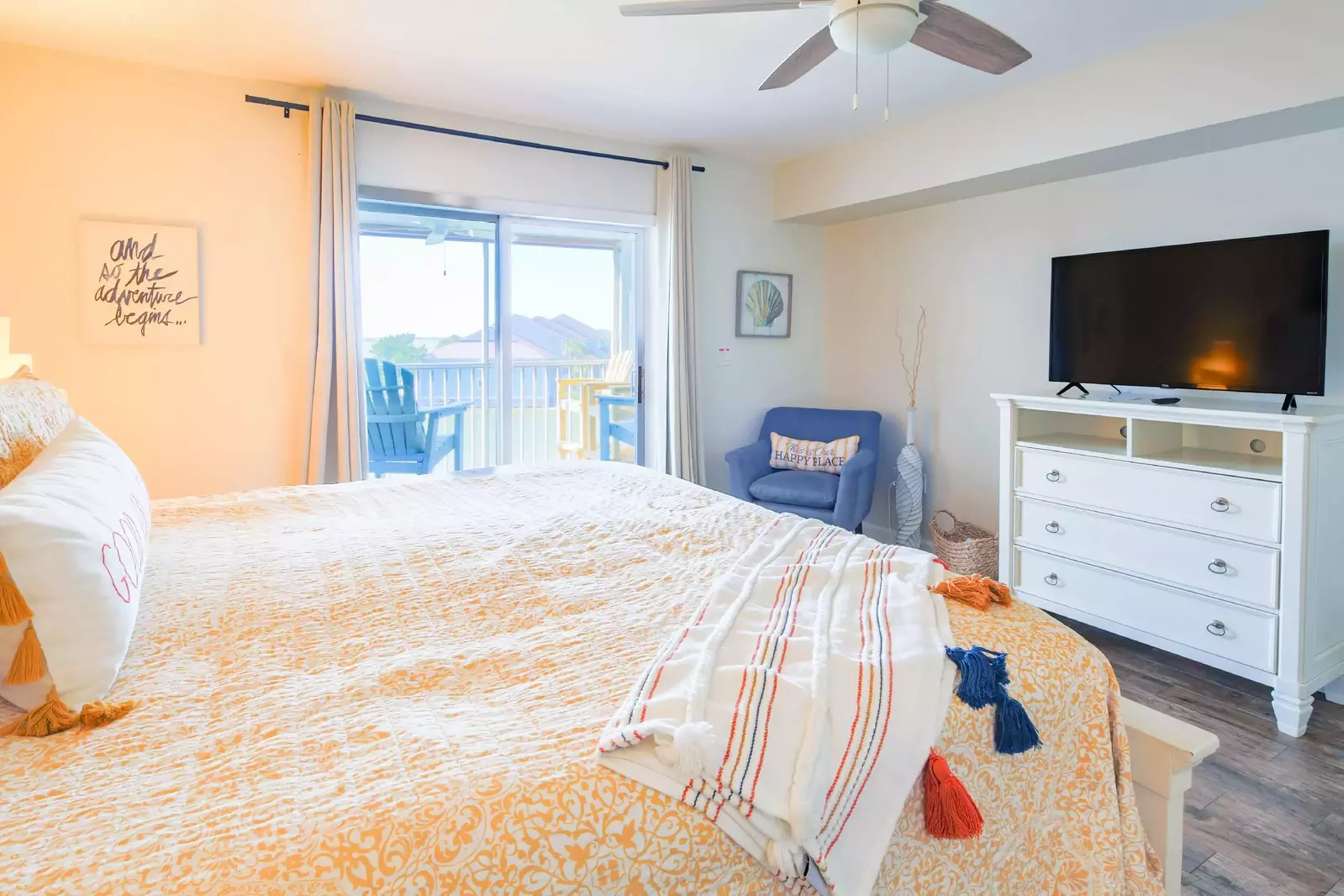 The master suite has a dresser, smart TV, arm chair and celing fan.