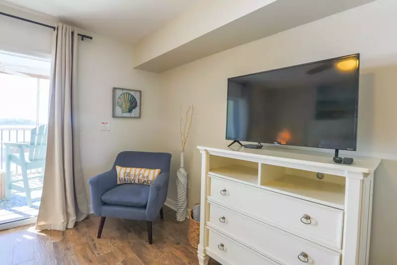 The master suite also has a dresser with a smart TV.
