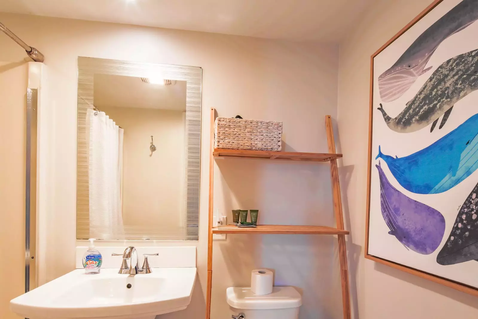 The en suite bathroom has a pedestal vanity and set of shelves.