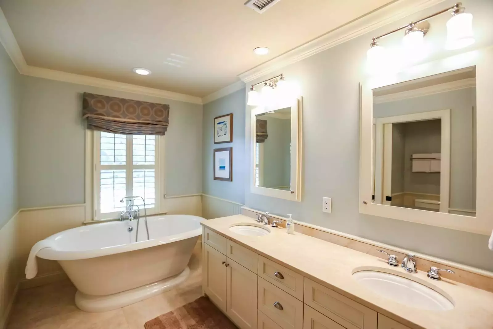 The master suite has a large, double-sink vanity, tiled floors and soaking tub.