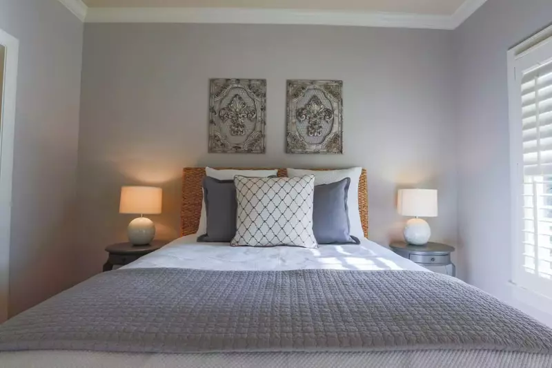 This guest bedroom has a queen bed and night stands with reading lamps.