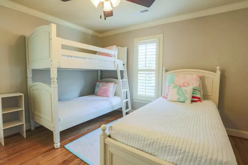 This guest bedroom has three twin sized beds -- two of the twin beds are bunked.