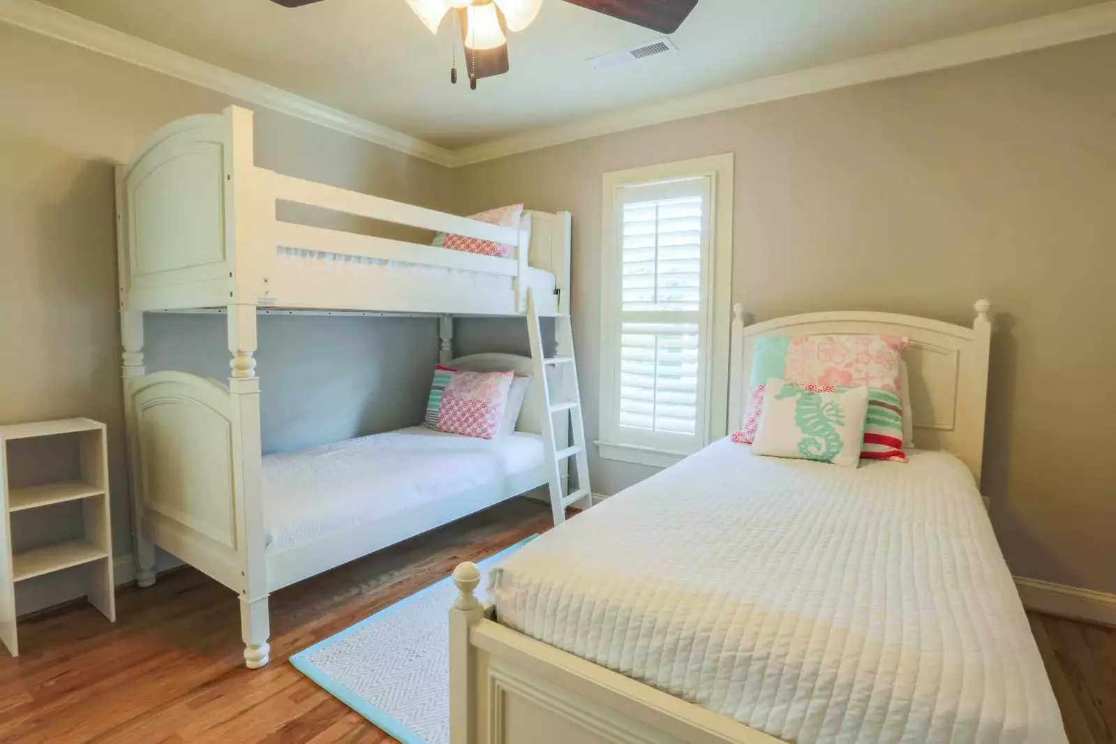 This guest bedroom has three twin sized beds -- two of the twin beds are bunked.