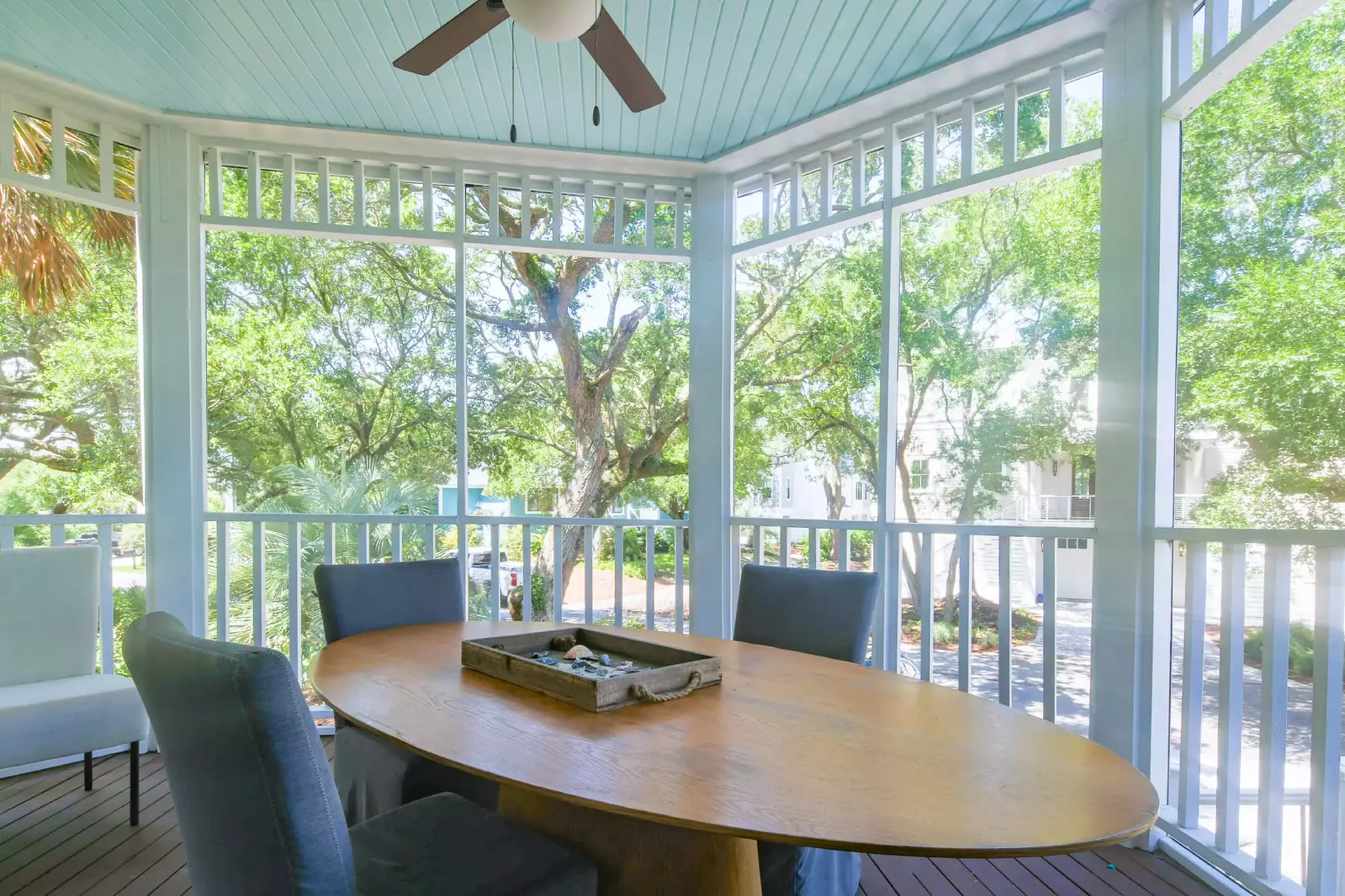 The screened porch with an outdoor dining table is accessible through the living room.