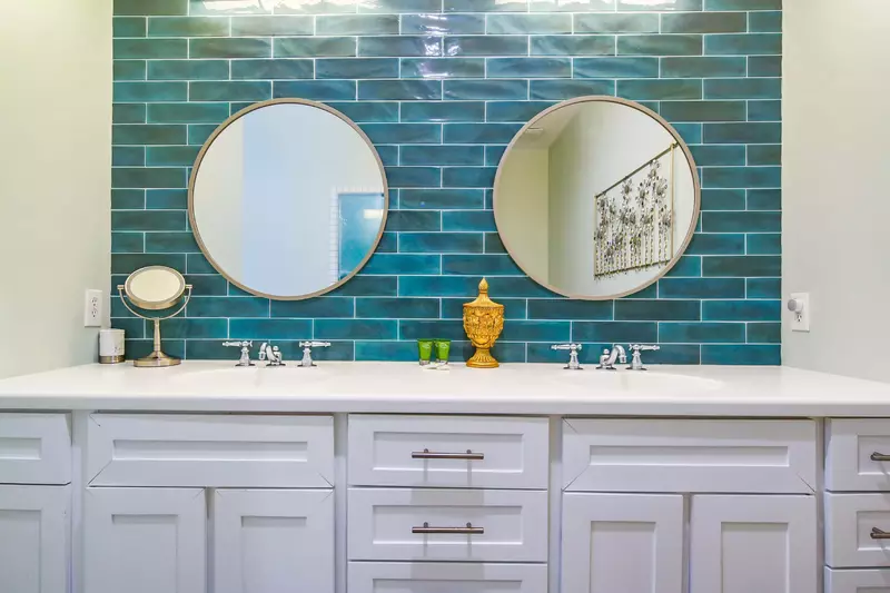 The en suite bathroom features a dual sink vanity and tiled backsplash.