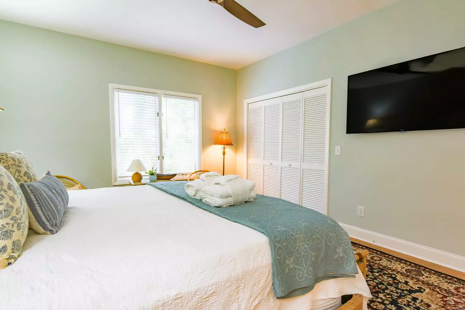 The guest suite also has a wall-mounted TV and a ceiling fan.