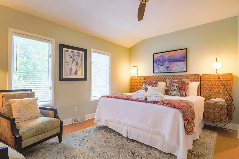 This guest bedroom features a king bed and night stands with wall sconces.